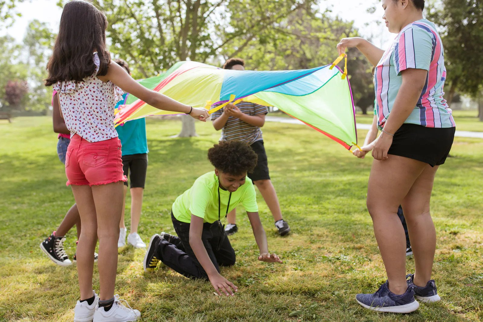 Children playing with a colorful parachute at a summer gathering